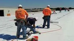 Excel Flat Roofing Professional roofer doing work on a commercial building roof